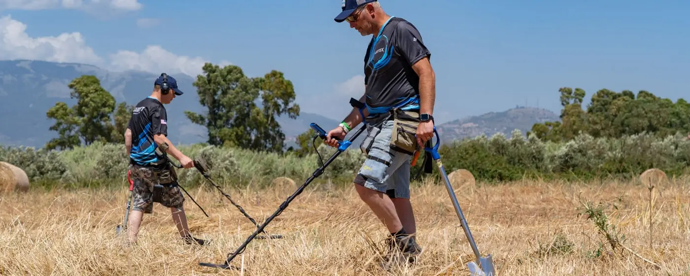 Persona che fa metal detecting in campagna italiana